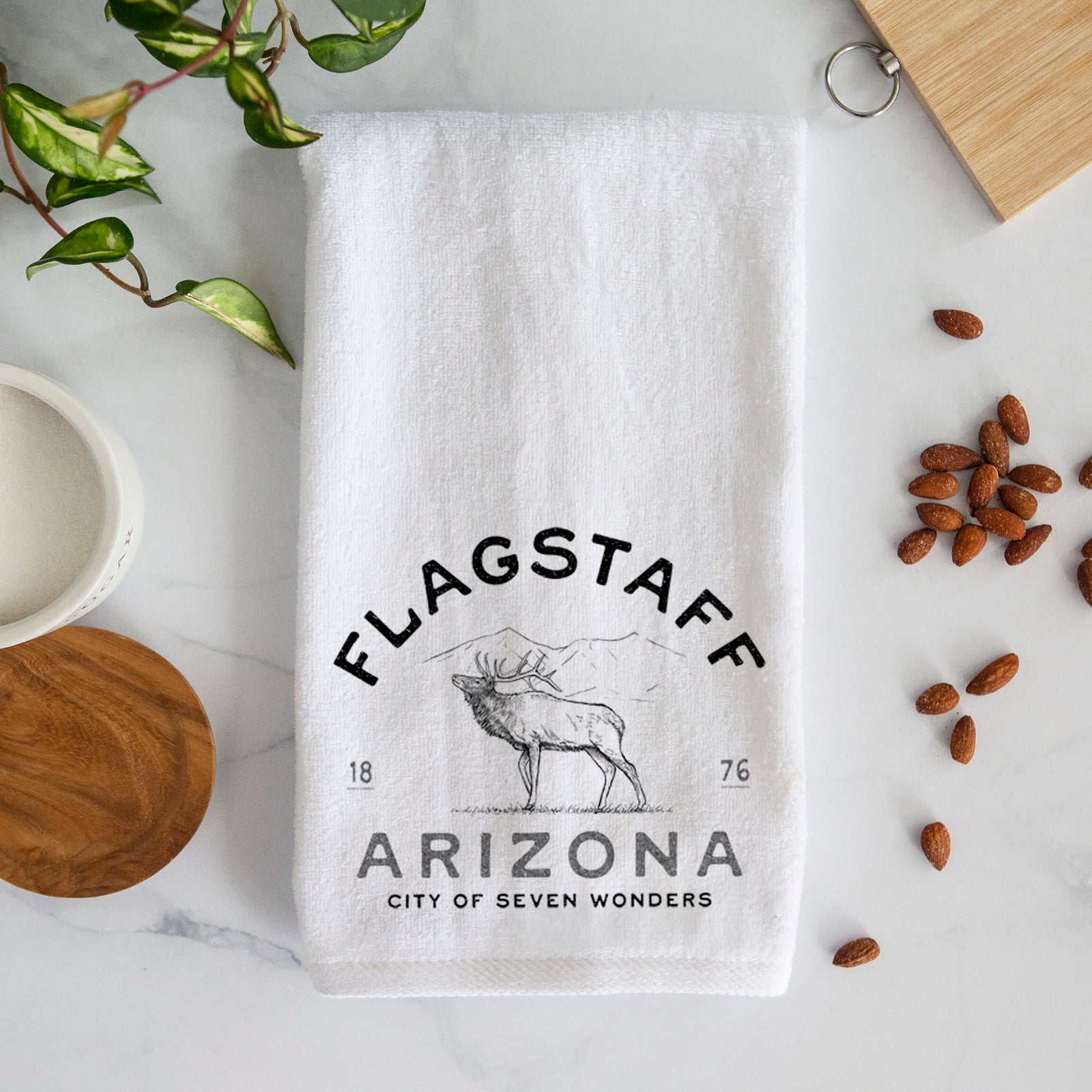 White hand towel printed with a black ink elk with the words Flagstaff Arizona, City of Seven Wonders.