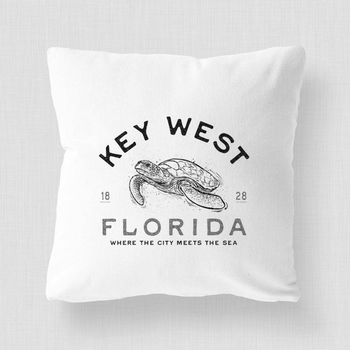 White pillow cover printed with a black ink sea turtle with the words Key West Florida.