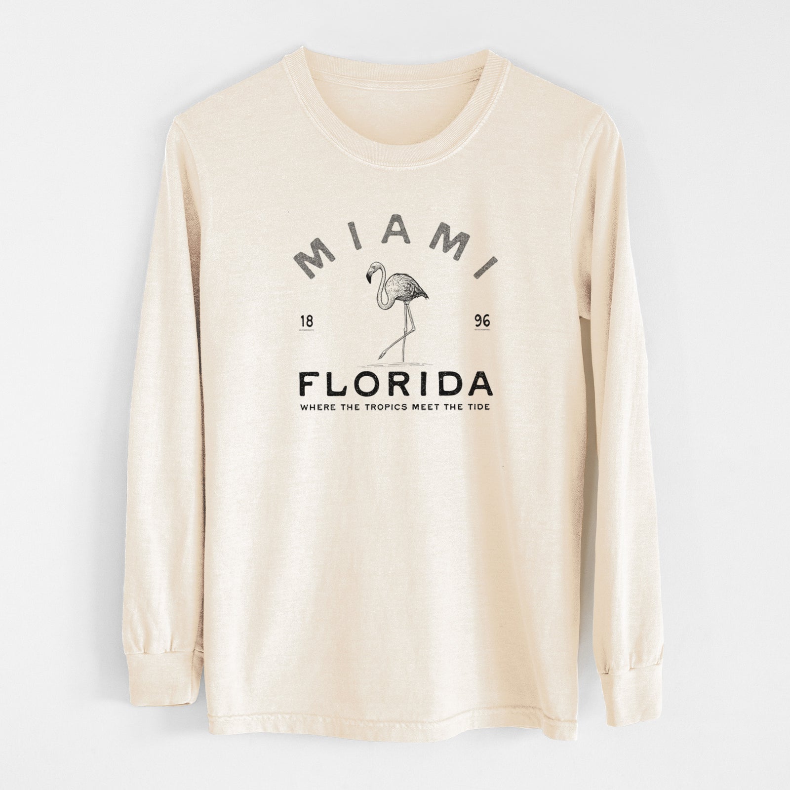 Ivory Comfort Colors long sleeve shirt laid flat, printed with a black ink flamingo with the words Miami Florida, 1896, Where the Tropics Meet the Tide.