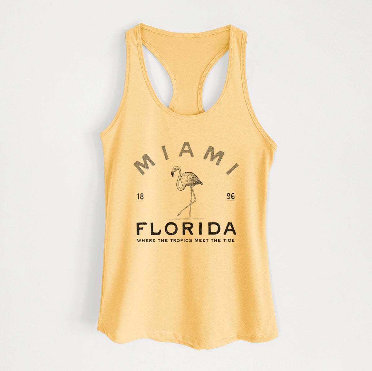 Banana cream women's racerback tank top laid flat, printed with a black ink flamingo with the words Miami Florida, 1896, Where the Tropics Meet the Tide.