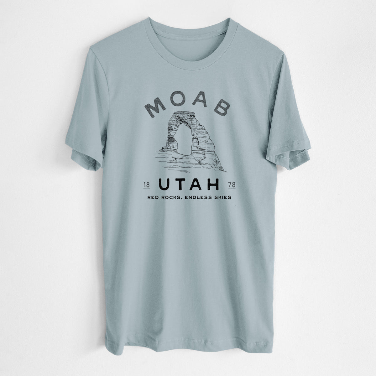 Vintage denim lightweight cotton t-shirt laid flat, printed with a black ink illustration of Delicate Arch with the words Moab Utah, 1878.