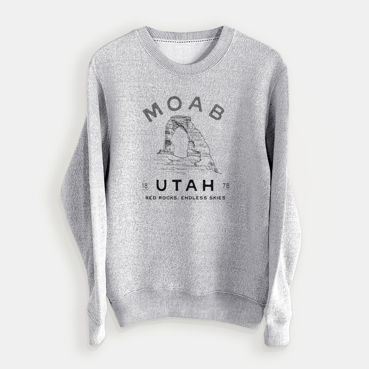 Salt and pepper knit sweatshirt laid flat, printed with a black ink illustration of Delicate Arch with the words Moab Utah, 1878.