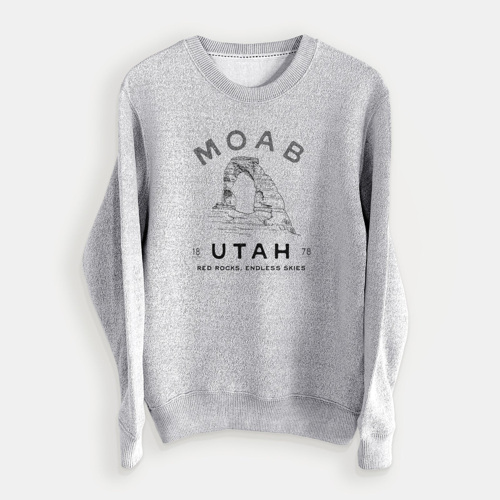 Salt and pepper knit sweatshirt laid flat, printed with a black ink illustration of Delicate Arch with the words Moab Utah, 1878.