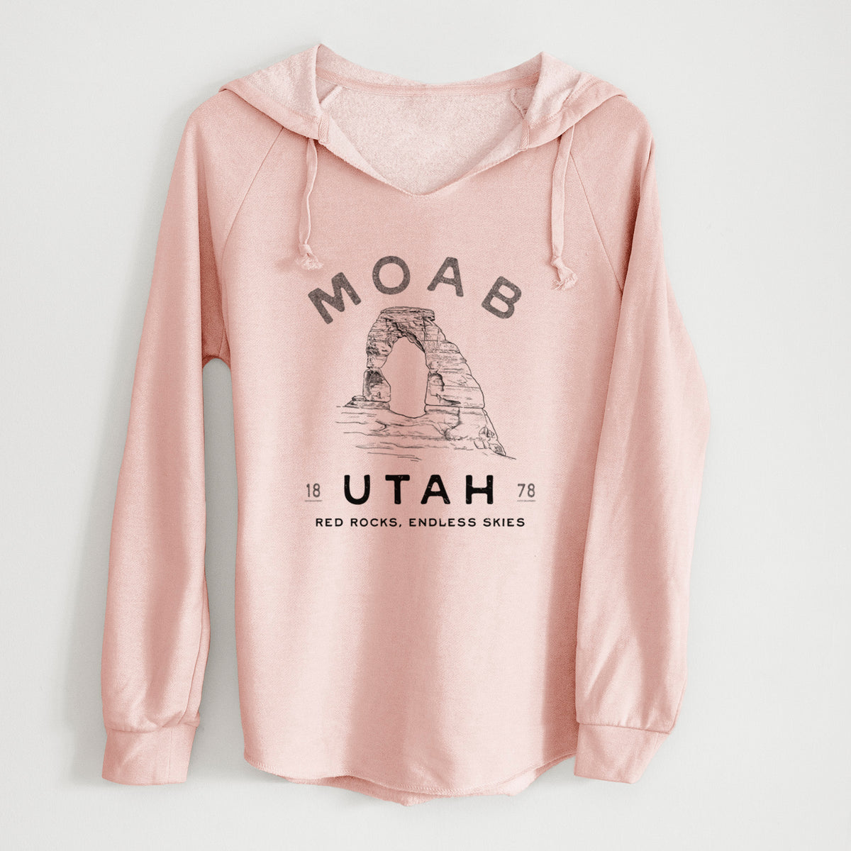 Blush pink women's Cali Wave hooded sweatshirt laid flat, printed with a black ink illustration of Delicate Arch with the words Moab Utah, 1878.