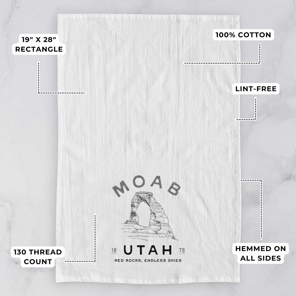 White tea towel printed with a black ink illustration of Delicate Arch with the words Moab Utah, 1878, with feature labels: 19 by 28 inch rectangle, 100% cotton, lint-free, 130 thread count, hemmed on all sides.