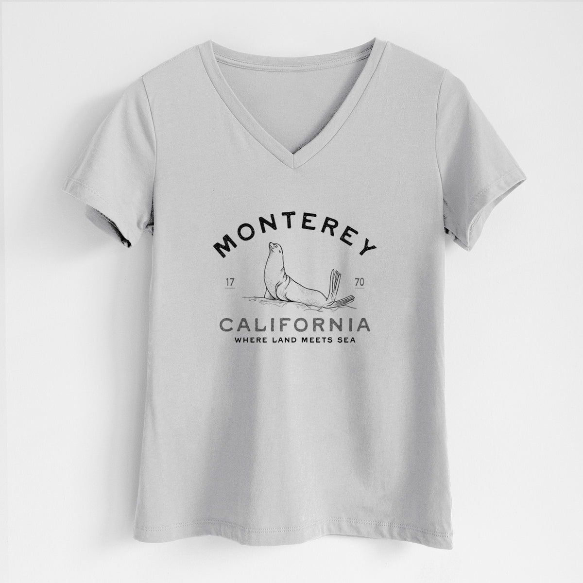 Lunar grey women's relaxed fit cotton V-neck t-shirt laid flat, printed with a black ink sea lion with the words Monterey California, 1770, Where Land Meets Sea.