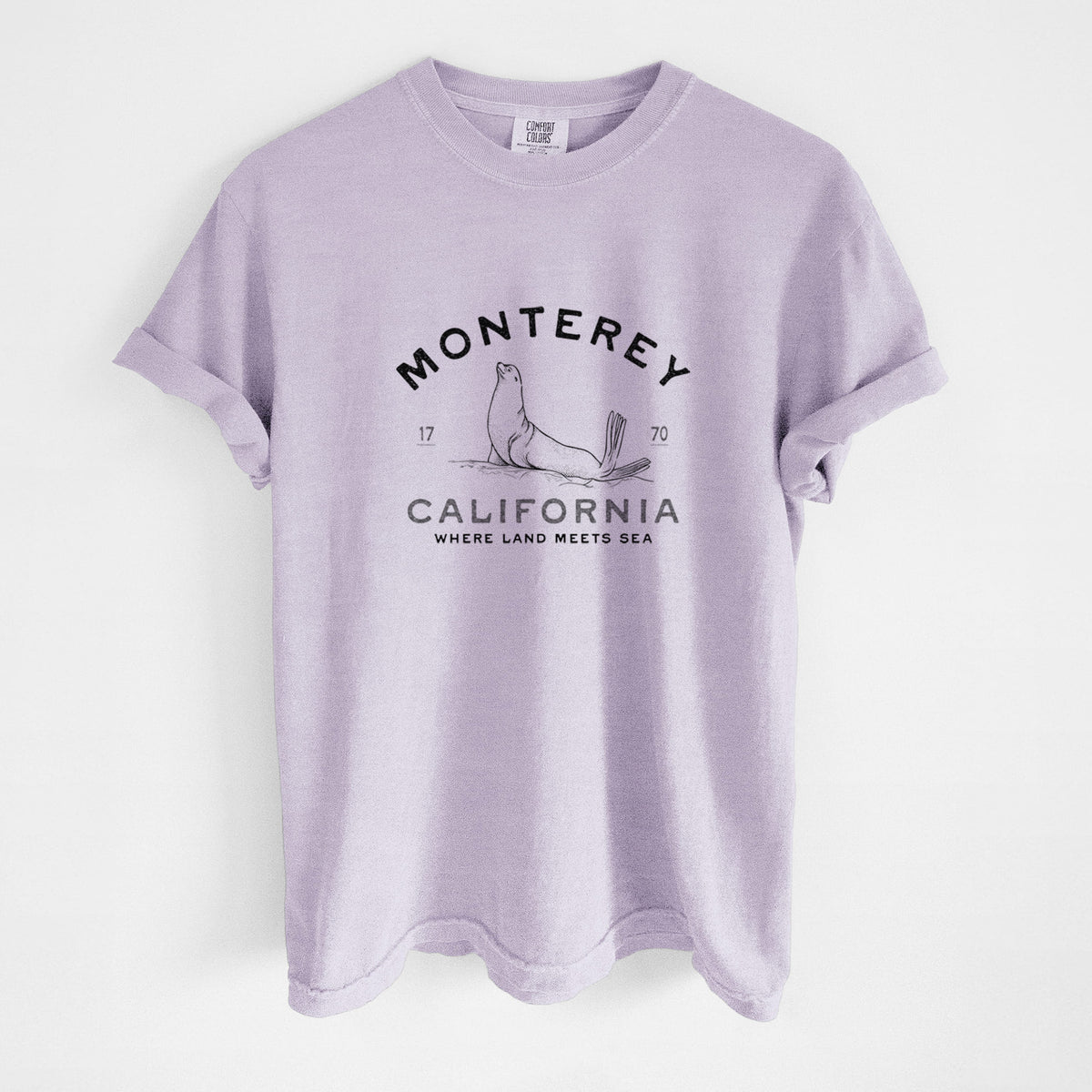 Orchid purple Comfort Colors t-shirt laid flat, printed with a black ink sea lion with the words Monterey California, 1770, Where Land Meets Sea.