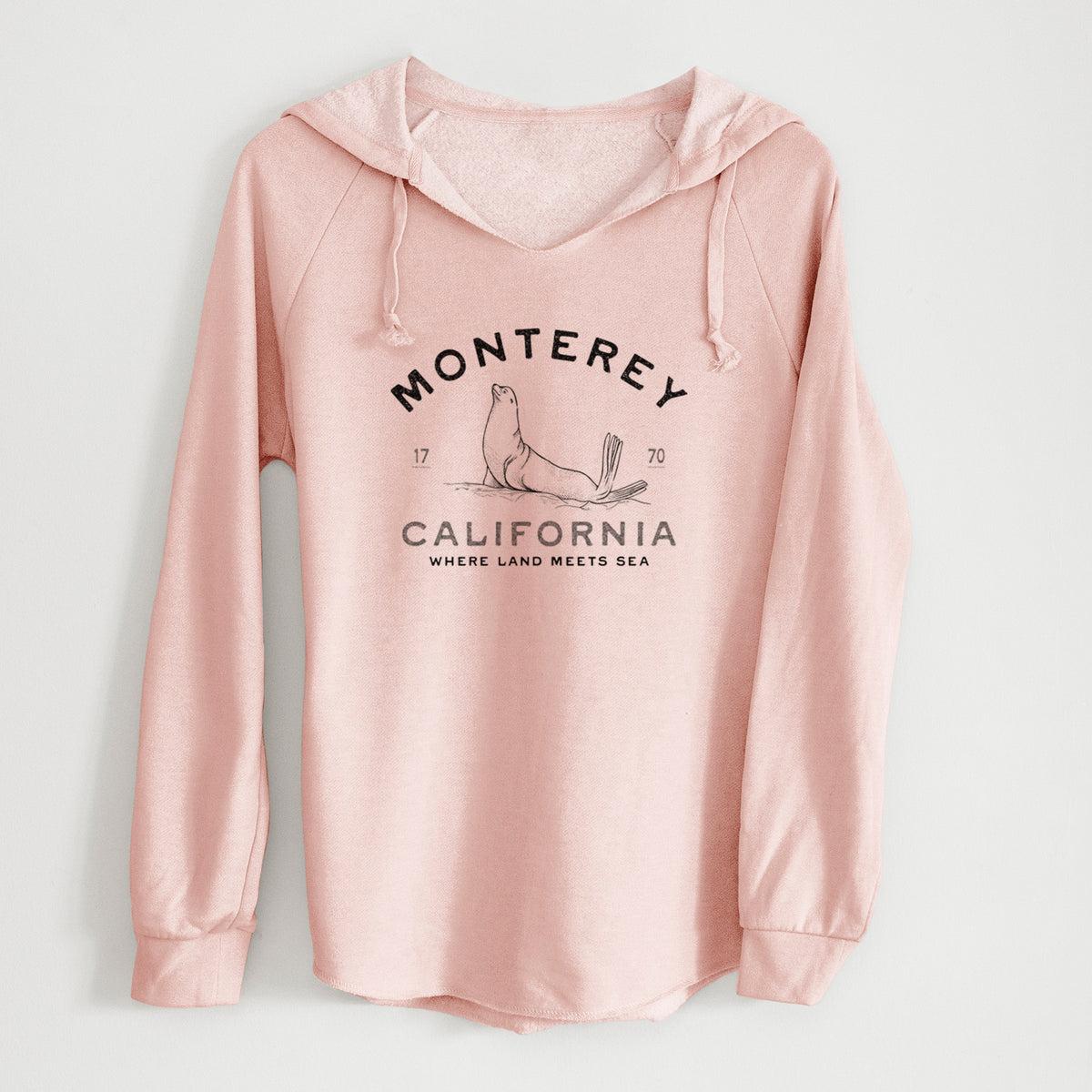 Blush pink women's Cali Wave hooded sweatshirt laid flat, printed with a black ink sea lion with the words Monterey California, 1770, Where Land Meets Sea.