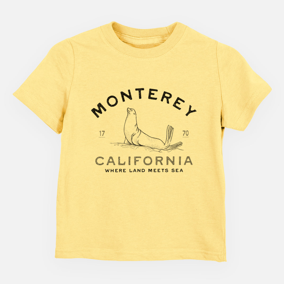 Butter yellow toddler t-shirt laid flat, printed with a black ink sea lion with the words Monterey California, 1770, Where Land Meets Sea.