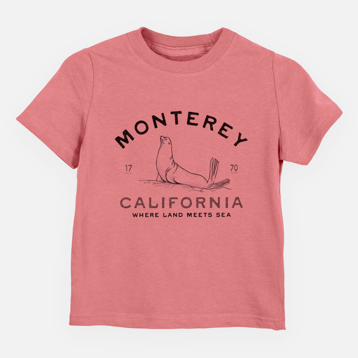 Mauve pink toddler t-shirt laid flat, printed with a black ink sea lion with the words Monterey California, 1770, Where Land Meets Sea.