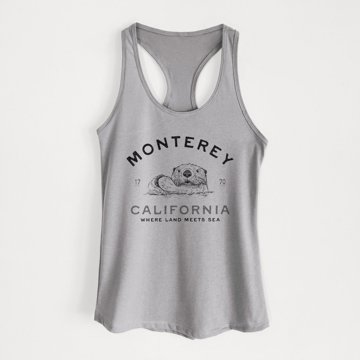Heather grey women's racerback tank top laid flat, printed with a black ink sea otter floating on its back, with the words Monterey California, 1770, Where Land Meets Sea.