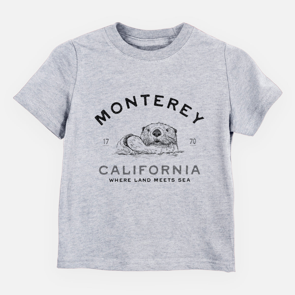 Heather grey toddler t-shirt laid flat, printed with a black ink sea otter floating on its back, with the words Monterey California, 1770, Where Land Meets Sea.