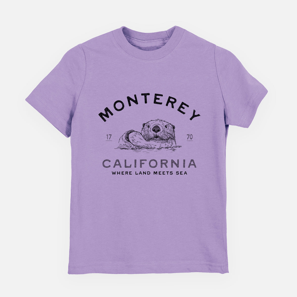 Lavender youth t-shirt laid flat, printed with a black ink sea otter floating on its back, with the words Monterey California, 1770, Where Land Meets Sea.