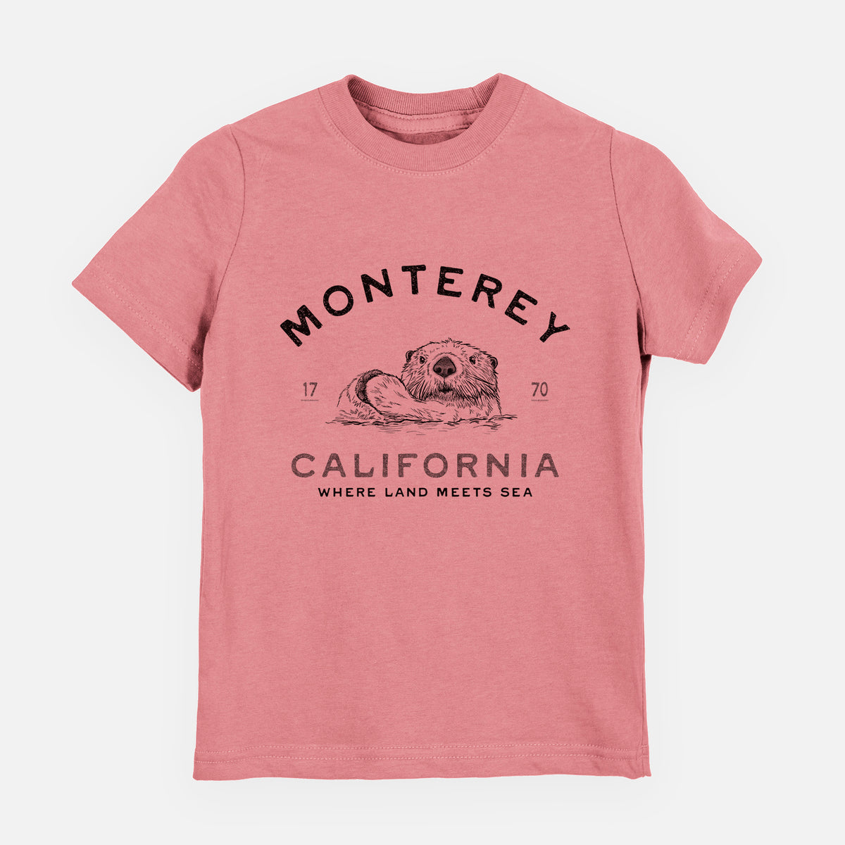 Mauve pink youth t-shirt laid flat, printed with a black ink sea otter floating on its back, with the words Monterey California, 1770, Where Land Meets Sea.