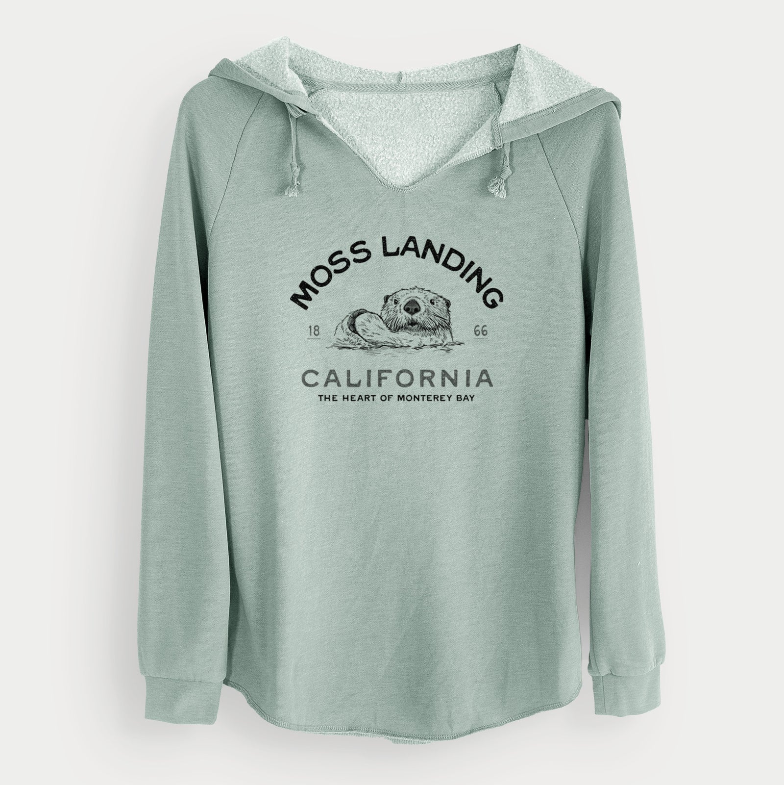 Sage green women's Cali Wave hooded sweatshirt laid flat, printed with a black ink sea otter with the words Moss Landing California, 1866, The Heart of Monterey Bay.
