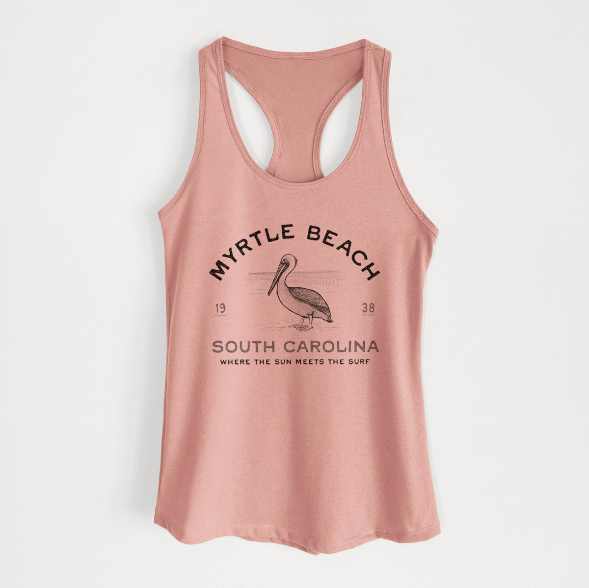 Desert pink women's racerback tank top laid flat, printed with a black ink pelican on a post with the words Myrtle Beach South Carolina, Where the Sun Meets the Surf.
