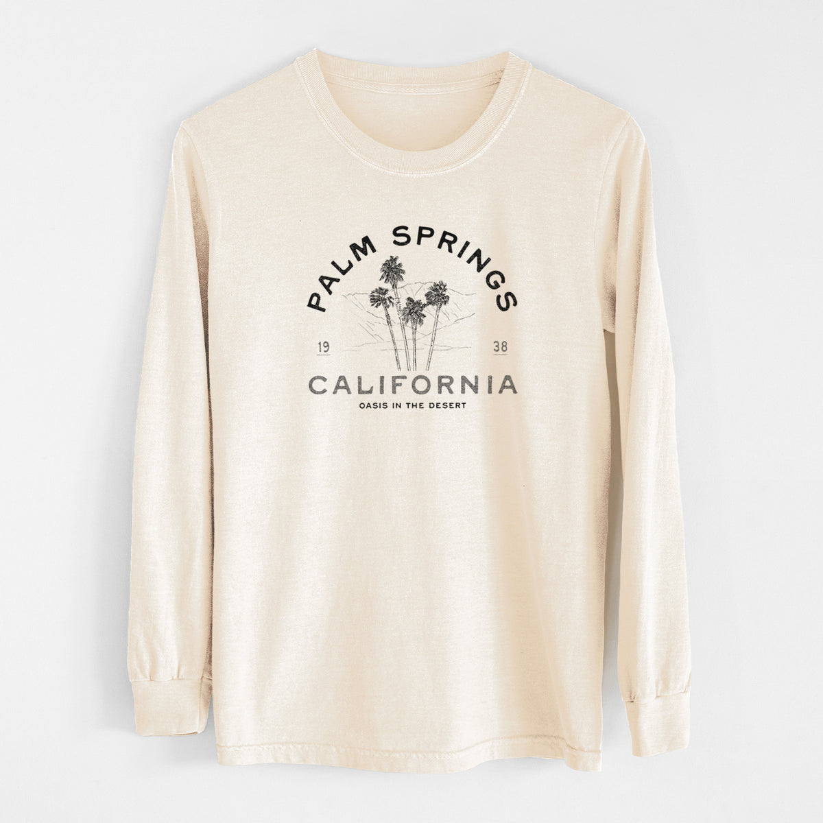Ivory Comfort Colors long sleeve shirt laid flat, printed with black ink palm trees with the words Palm Springs California, 1938, Oasis in the Desert.