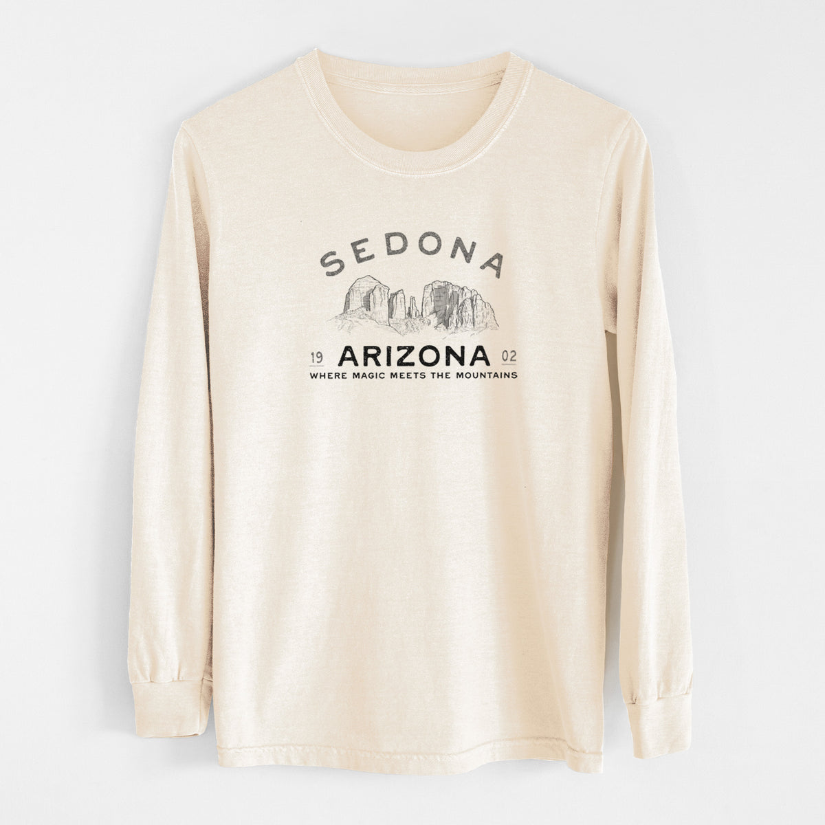 Ivory Comfort Colors long sleeve shirt laid flat, printed with black ink red rock buttes with the words Sedona Arizona, Where Magic Meets the Mountains.