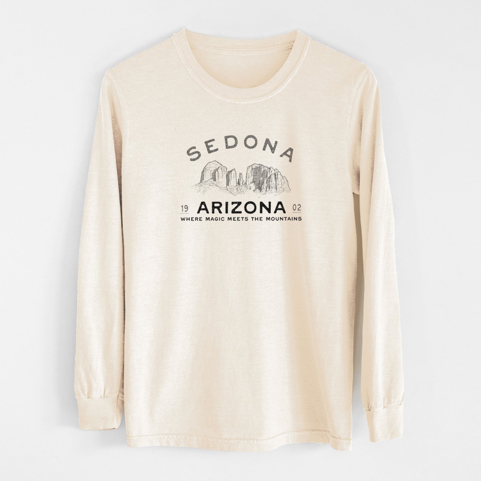 Ivory Comfort Colors long sleeve shirt laid flat, printed with black ink red rock buttes with the words Sedona Arizona, Where Magic Meets the Mountains.