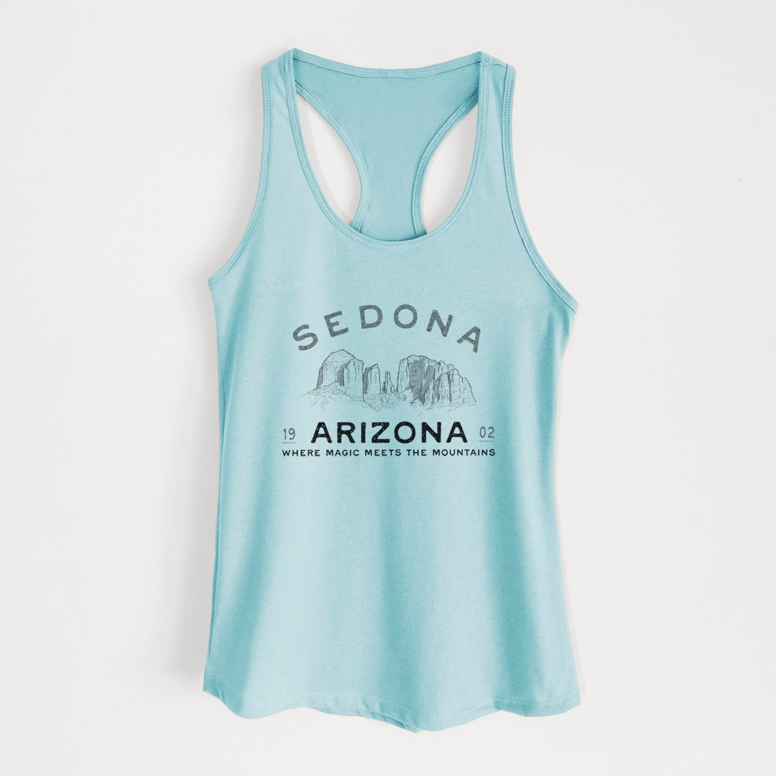 Banana cream women's racerback tank top laid flat, printed with black ink red rock buttes with the words Sedona Arizona, Where Magic Meets the Mountains.