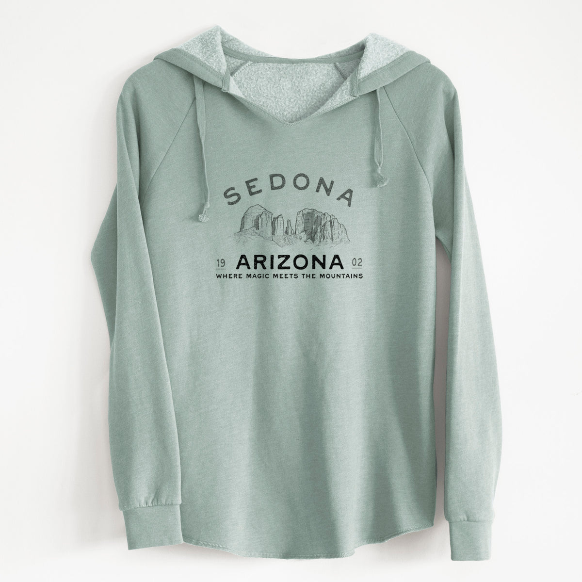 Sage green women's Cali Wave hooded sweatshirt laid flat, printed with black ink red rock buttes with the words Sedona Arizona, Where Magic Meets the Mountains.