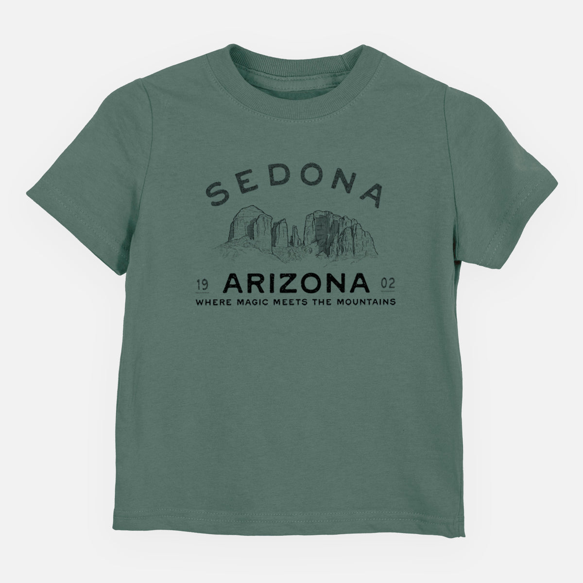Basil green toddler t-shirt laid flat, printed with black ink red rock buttes with the words Sedona Arizona, Where Magic Meets the Mountains.