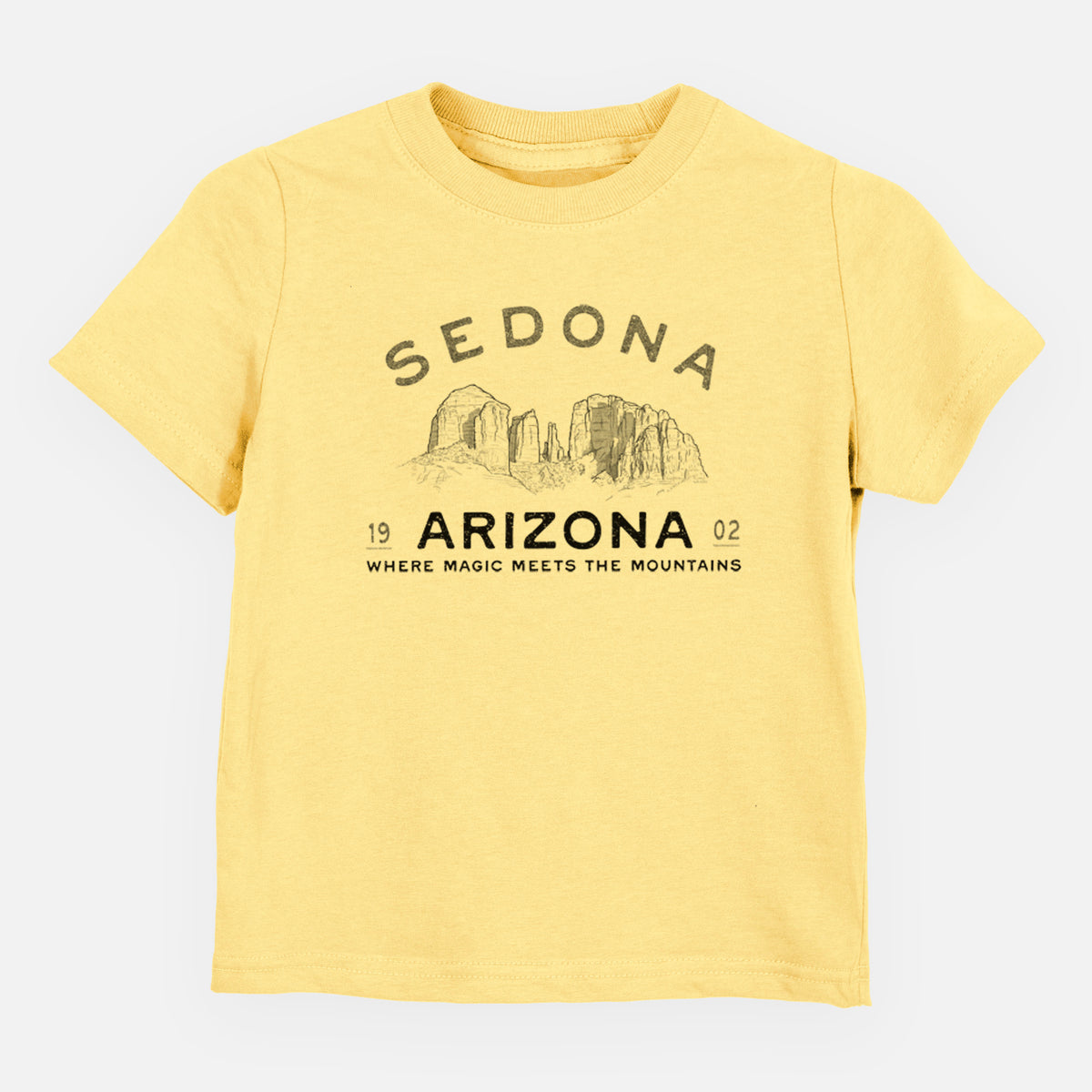 Butter yellow toddler t-shirt laid flat, printed with black ink red rock buttes with the words Sedona Arizona, Where Magic Meets the Mountains.
