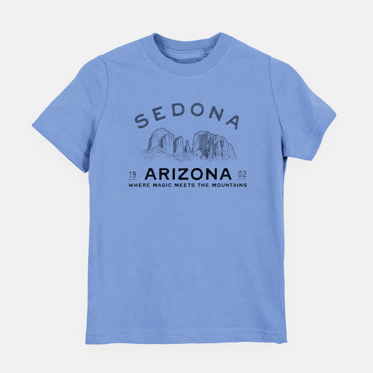 Carolina blue youth t-shirt laid flat, printed with black ink red rock buttes with the words Sedona Arizona, Where Magic Meets the Mountains.