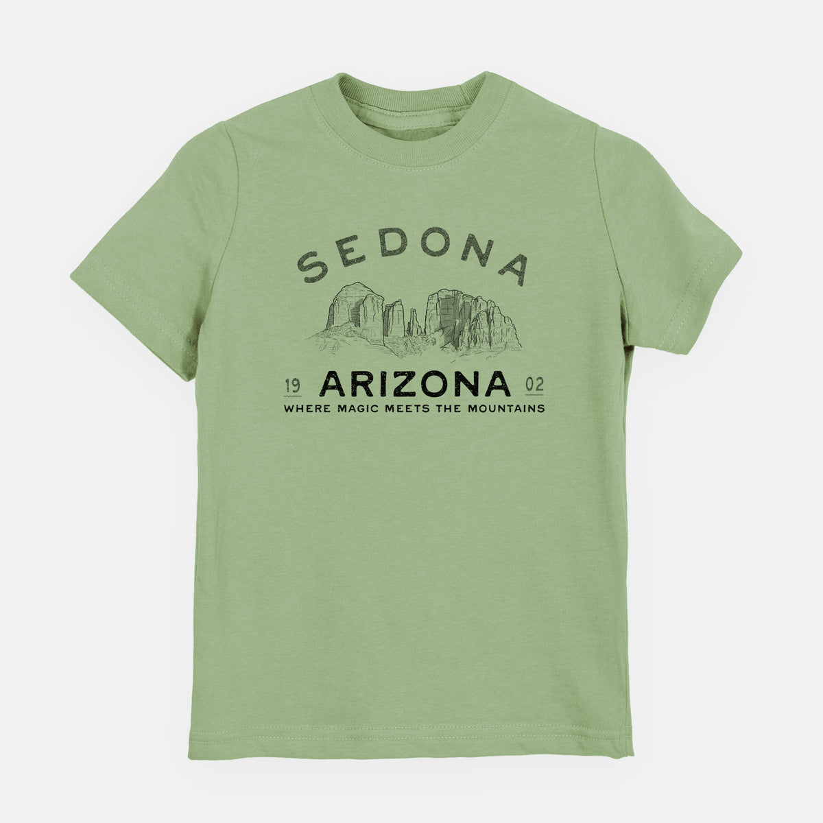 Sage green youth t-shirt laid flat, printed with black ink red rock buttes with the words Sedona Arizona, Where Magic Meets the Mountains.