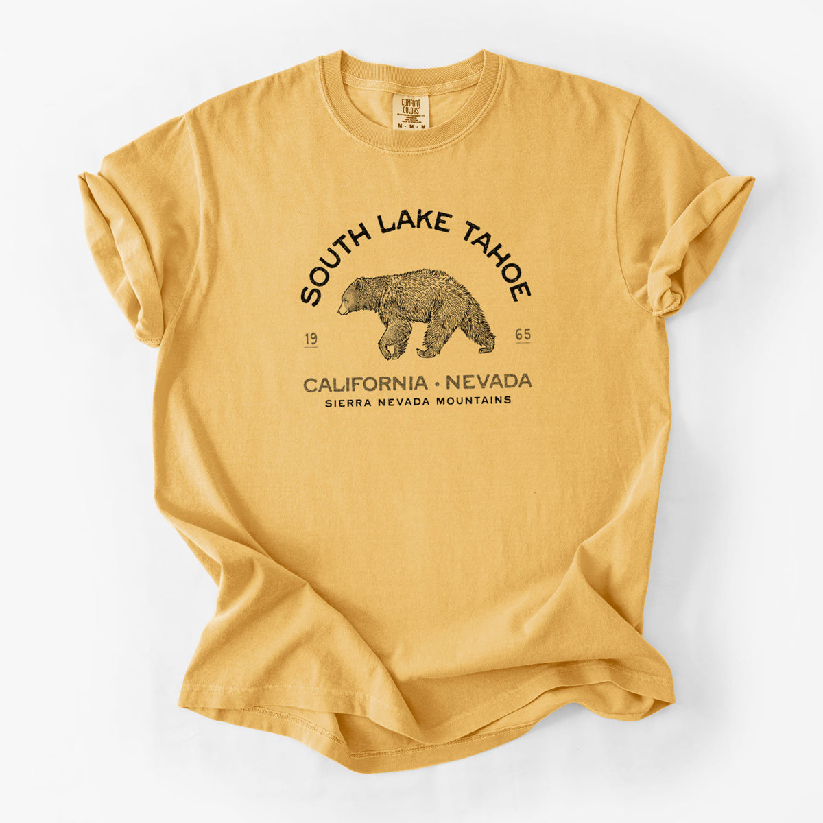 Golden wheat yellow Comfort Colors t-shirt laid flat, printed with a black ink bear with the words South Lake Tahoe, California - Nevada, Sierra Nevada Mountains.