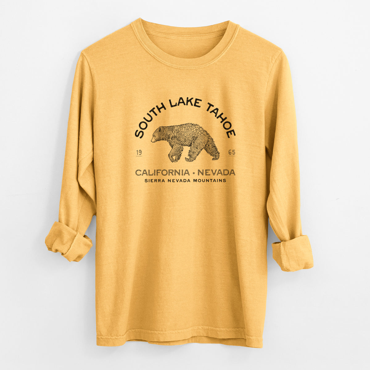 Golden wheat yellow Comfort Colors long sleeve shirt laid flat with the cuffs rolled, printed with a black ink bear with the words South Lake Tahoe, California - Nevada, Sierra Nevada Mountains.