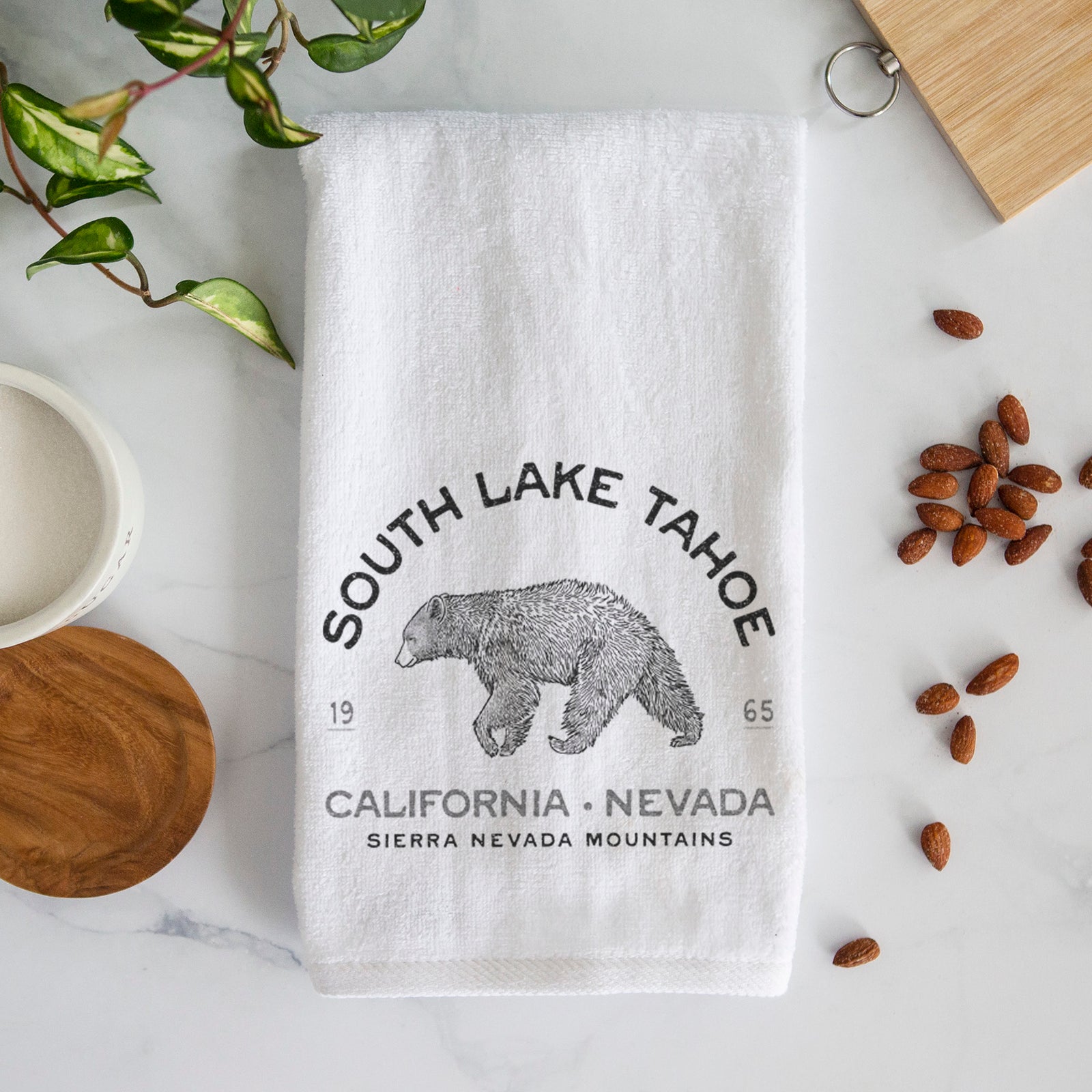 White hand towel printed with a black ink bear with the words South Lake Tahoe, California - Nevada, Sierra Nevada Mountains.