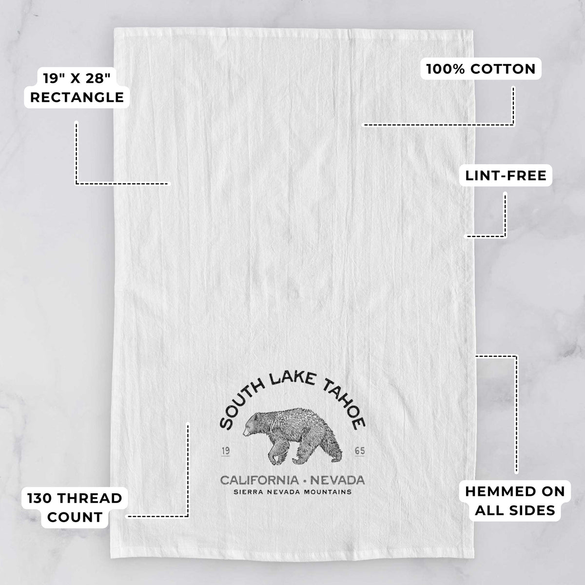 White tea towel printed with a black ink bear with the words South Lake Tahoe, California - Nevada, Sierra Nevada Mountains, with feature labels: 19 by 28 inch rectangle, 100% cotton, lint-free, 130 thread count, hemmed on all sides.