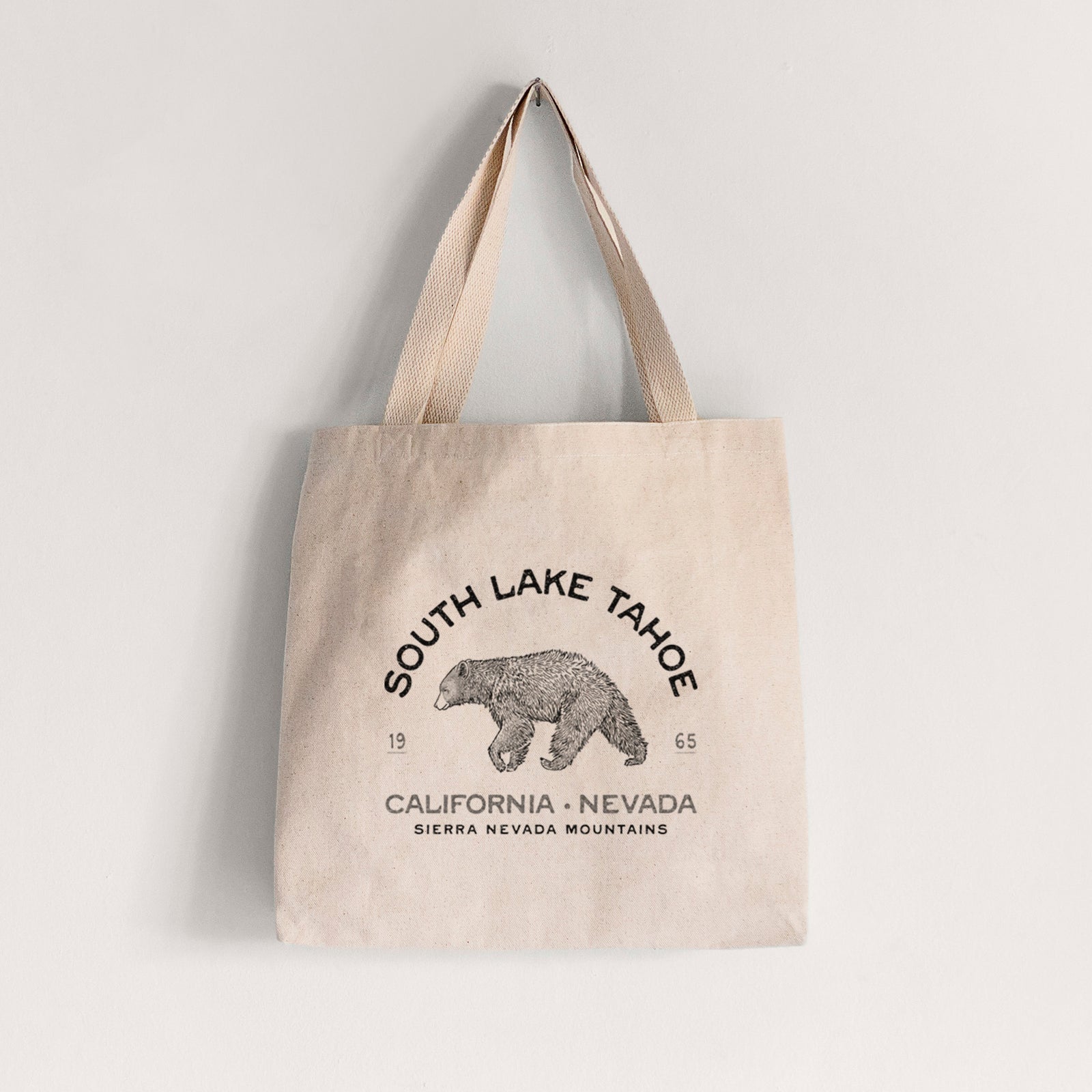 Natural canvas tote bag printed with a black ink bear with the words South Lake Tahoe, California - Nevada, Sierra Nevada Mountains.