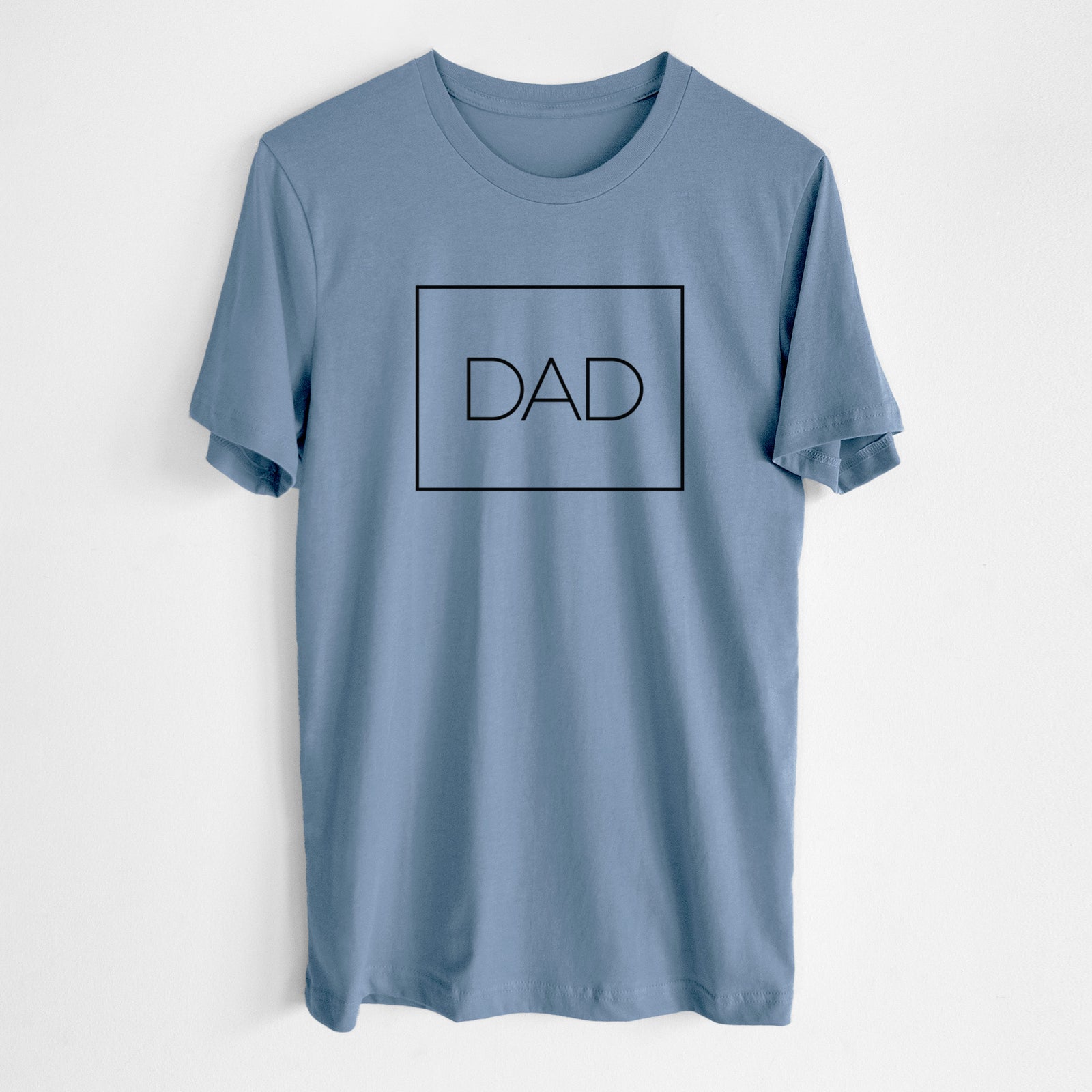 Steel blue lightweight cotton t-shirt laid flat, printed with the word DAD in thin black letters inside a square outline.