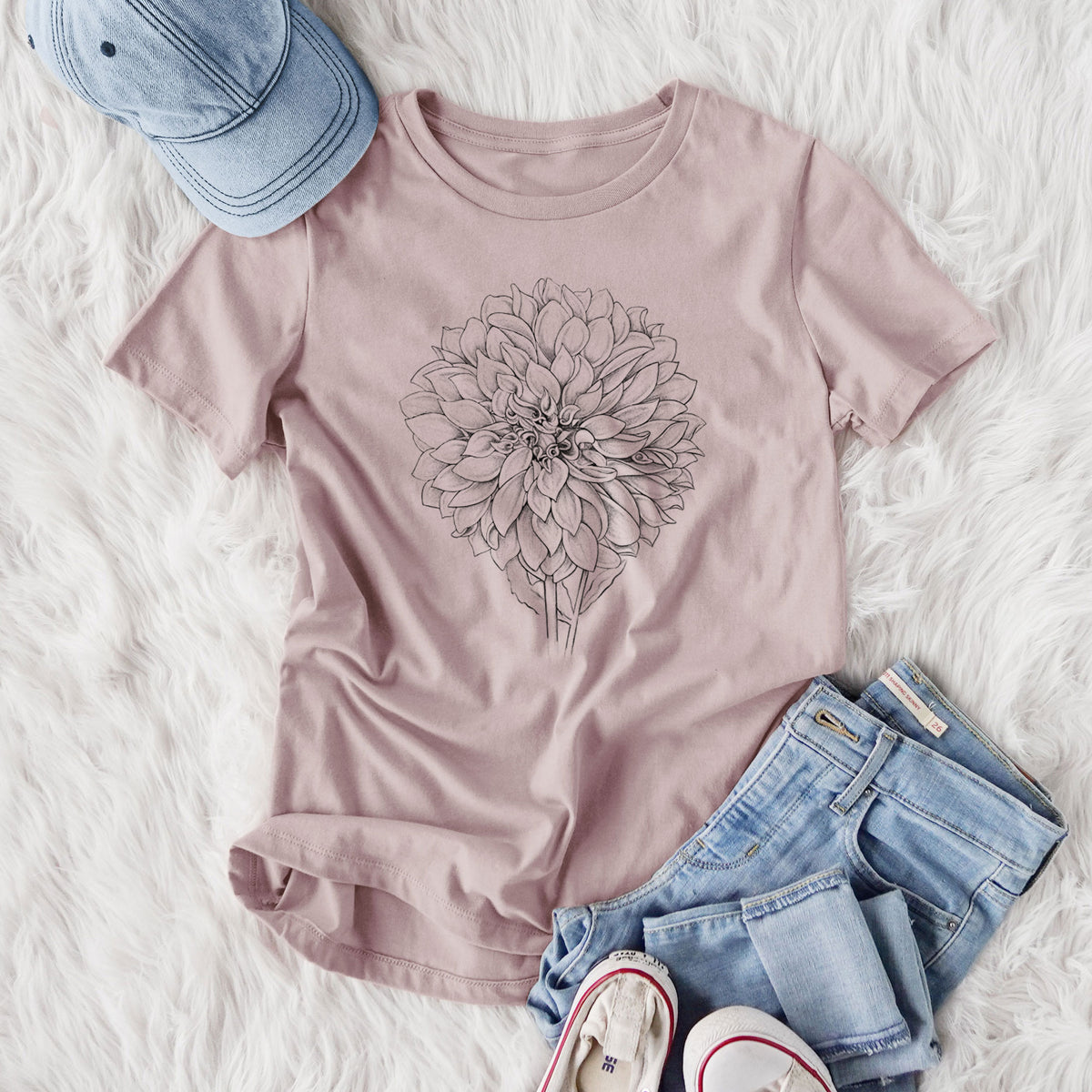 Women's relaxed fit cotton t-shirt printed with a detailed black ink line drawing of a Cafe au Lait dahlia bloom, styled flat on a white faux fur rug with jeans.