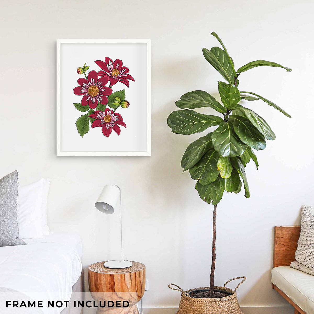 Art print of a full-color illustration of deep red dahlia flowers with green leaves and a small bee, shown framed on a living room wall beside a potted plant. Frame not included.