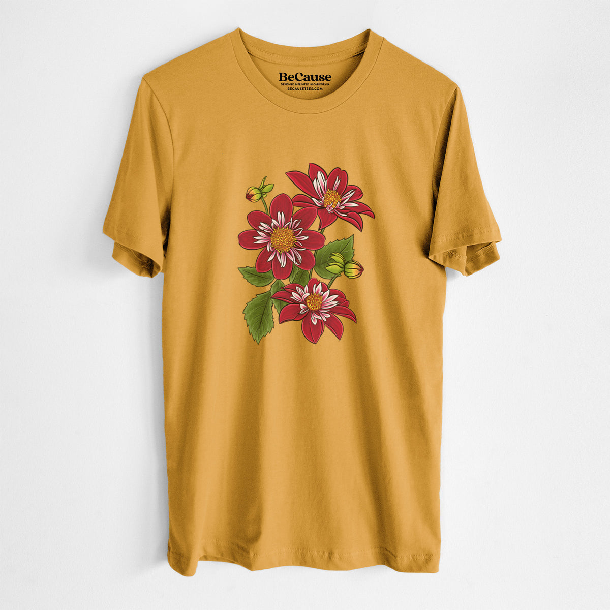 Mustard yellow lightweight cotton t-shirt laid flat, printed with a full-color illustration of deep red dahlia flowers with green leaves and a small bee.