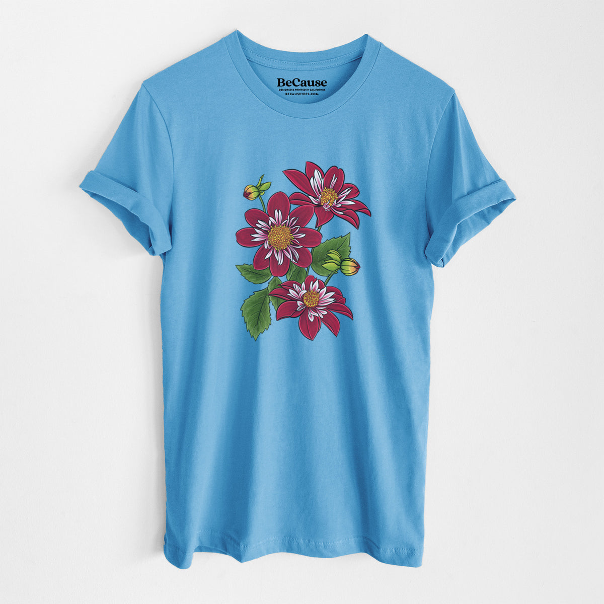 Ocean blue lightweight cotton t-shirt laid flat, printed with a full-color illustration of deep red dahlia flowers with green leaves and a small bee.