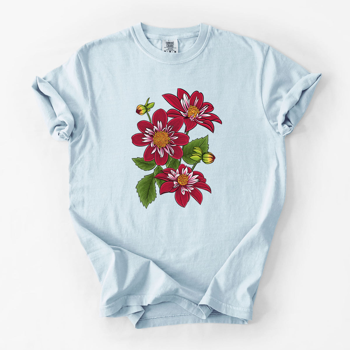 Chambray blue Comfort Colors t-shirt laid flat, printed with a full-color illustration of deep red dahlia flowers with green leaves and a small bee.