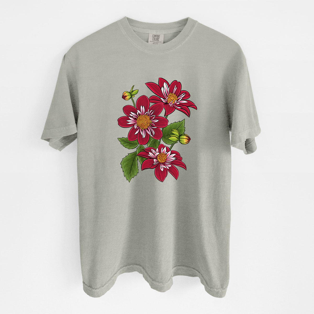 Sandstone beige Comfort Colors t-shirt laid flat, printed with a full-color illustration of deep red dahlia flowers with green leaves and a small bee.