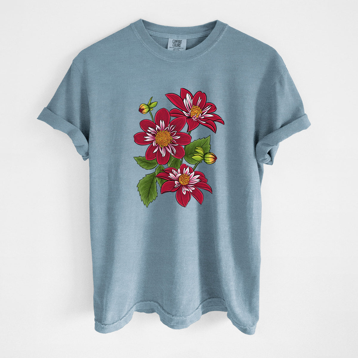 Steel blue Comfort Colors t-shirt laid flat, printed with a full-color illustration of deep red dahlia flowers with green leaves and a small bee.