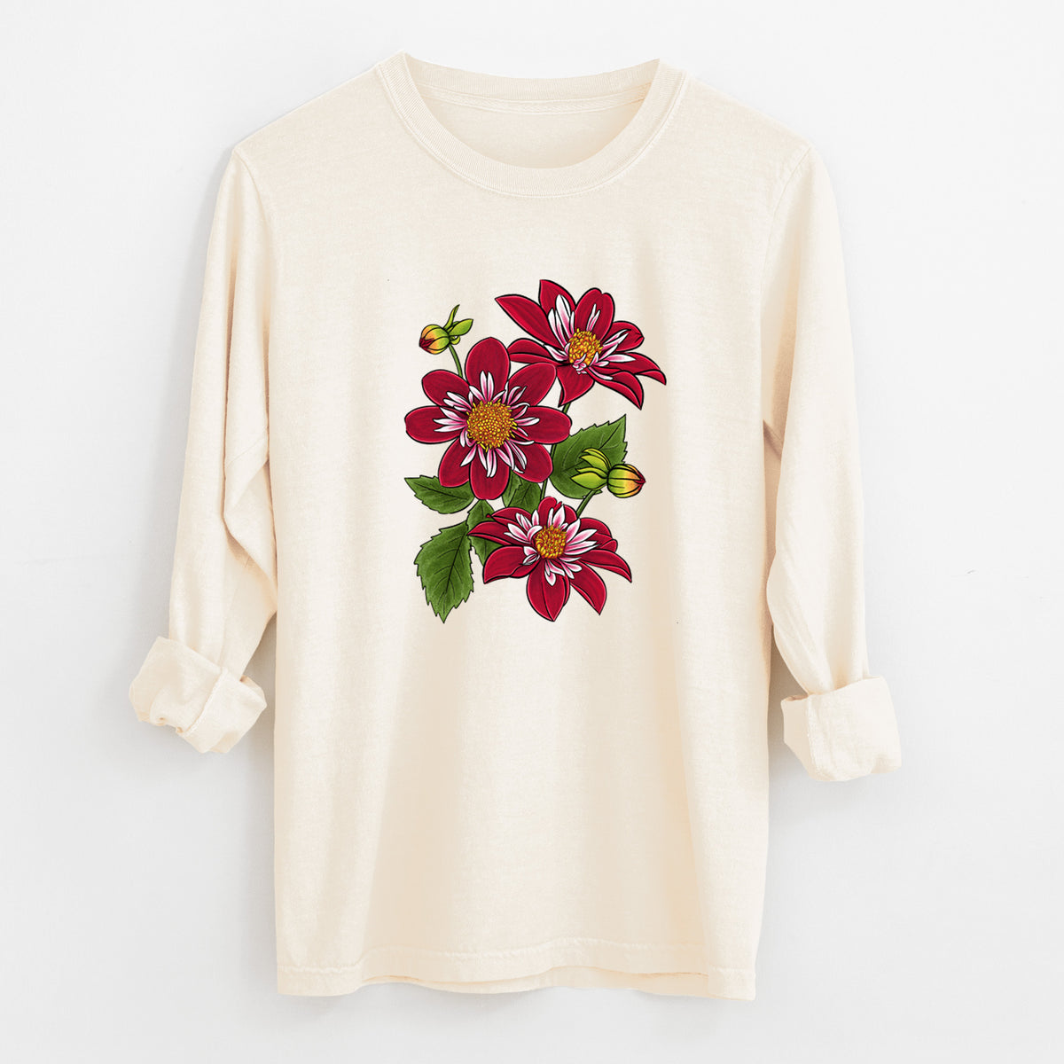 Ivory Comfort Colors long sleeve shirt laid flat with the cuffs rolled, printed with a full-color illustration of deep red dahlia flowers with green leaves and a small bee.