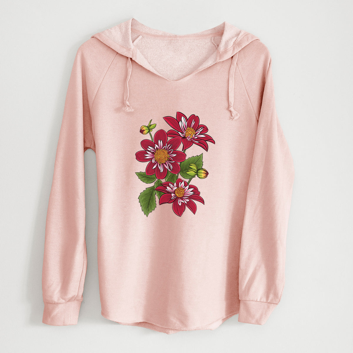 Blush pink women's Cali Wave hooded sweatshirt laid flat, printed with a full-color illustration of deep red dahlia flowers with green leaves and a small bee.