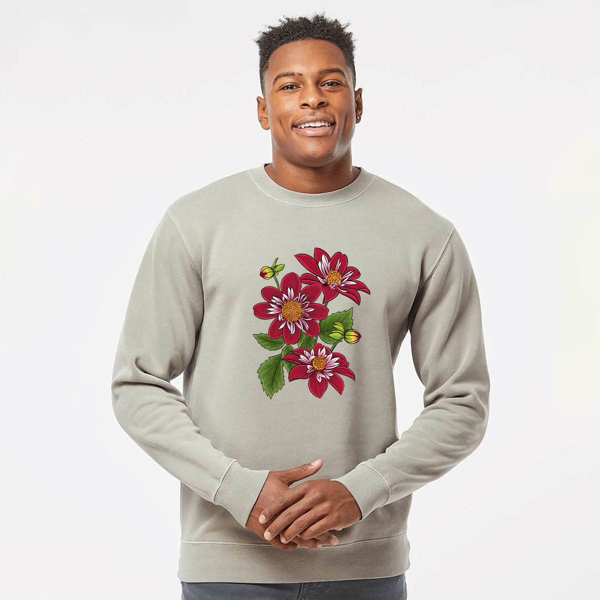 Model wearing a cement grey pigment dyed crewneck sweatshirt printed with a full-color illustration of deep red dahlia flowers with green leaves and a small bee.