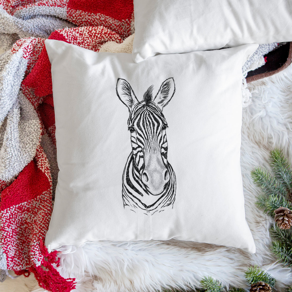 White pillow cover printed with a detailed black ink portrait of a Damara zebra facing forward, on a woven chair.