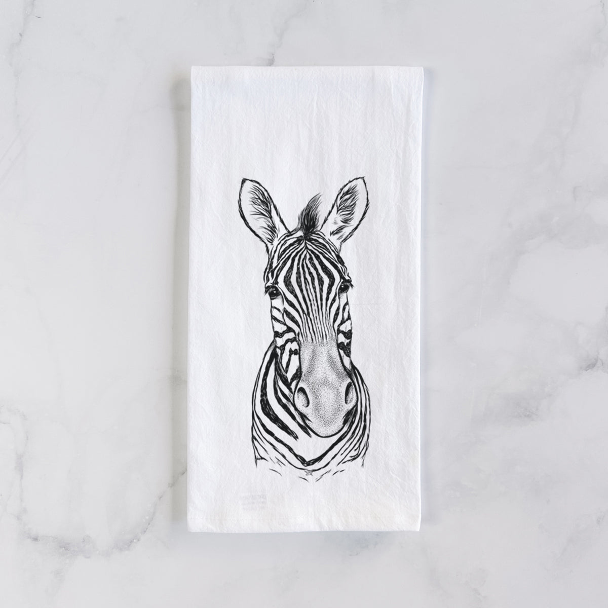 White cotton tea towel laid flat on marble, printed with a detailed black ink portrait of a Damara zebra facing forward.