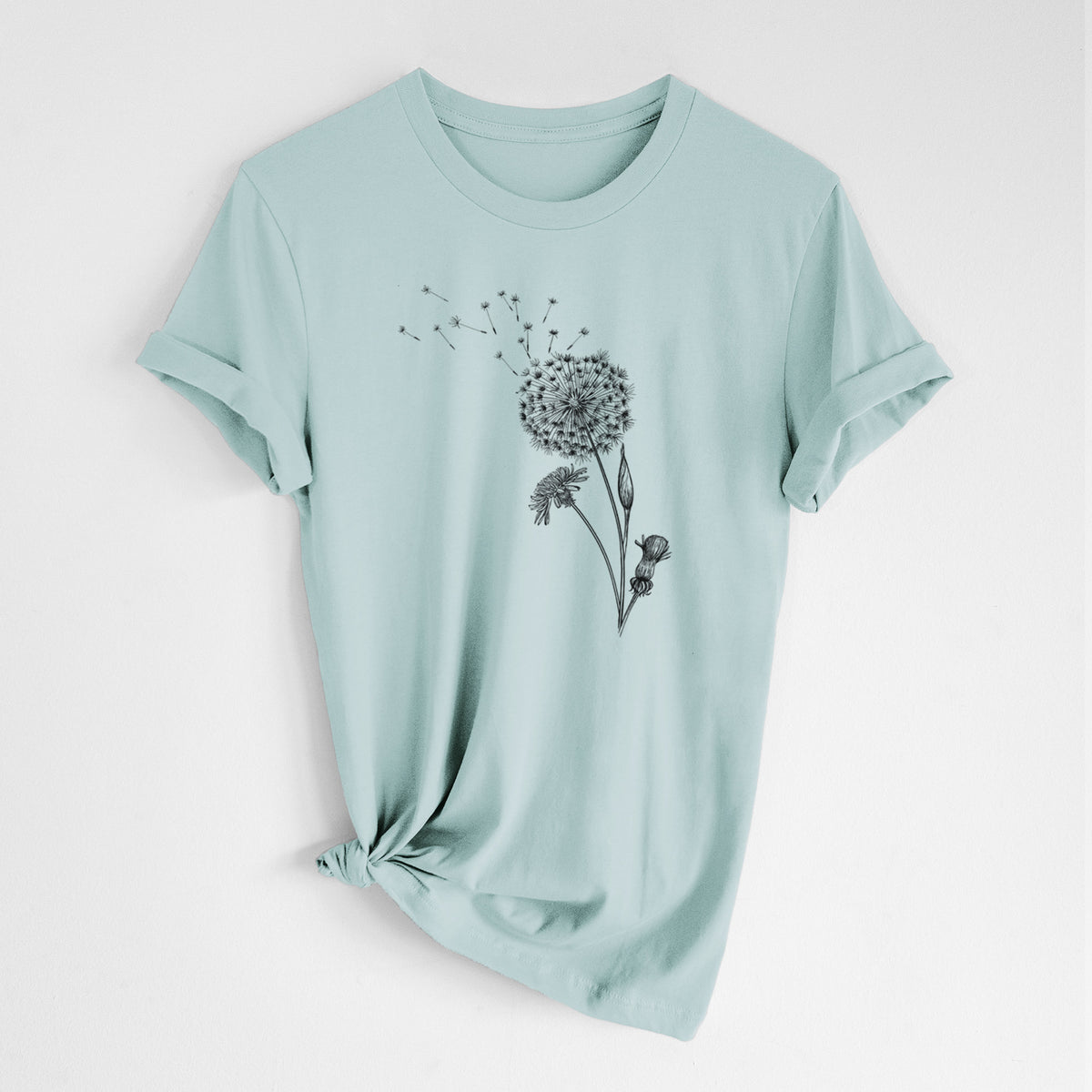 Dusty blue lightweight cotton t-shirt laid flat with the sleeves rolled, printed with a black ink line drawing of a dandelion seed head with seeds blowing away.