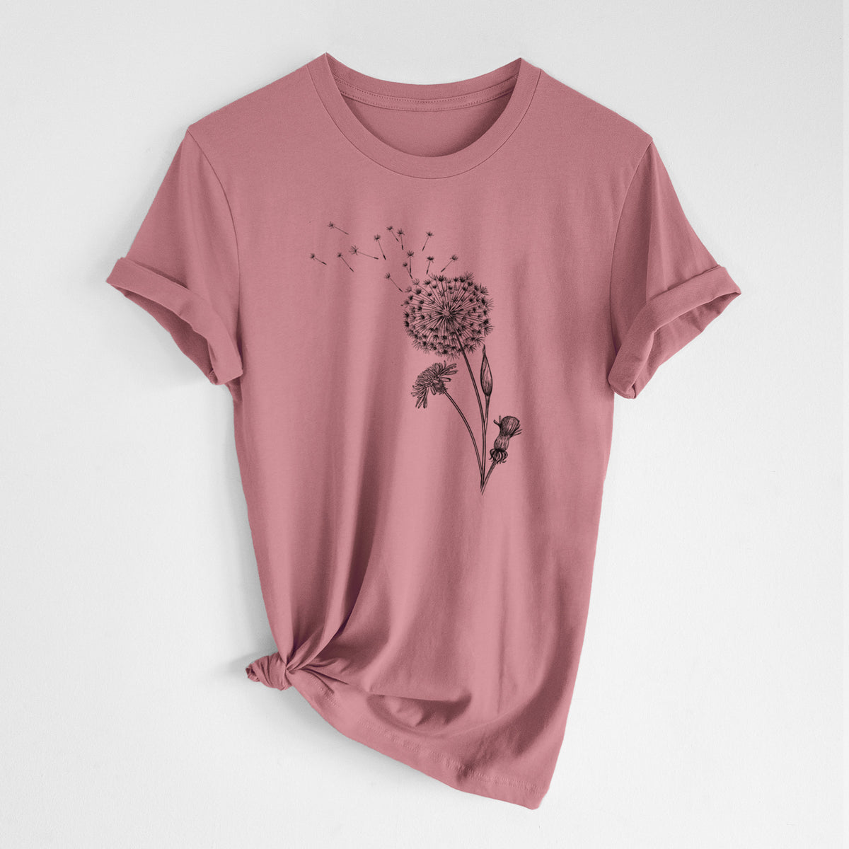 Mauve pink lightweight cotton t-shirt laid flat with the sleeves rolled, printed with a black ink line drawing of a dandelion seed head with seeds blowing away.