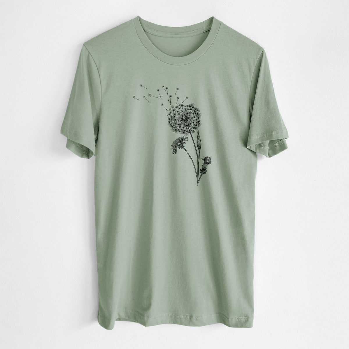 Sage green lightweight cotton t-shirt laid flat, printed with a black ink line drawing of a dandelion seed head with seeds blowing away.